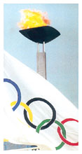 Il tripode con la fiammma olimpica e la bandiera con i cinque cerchi