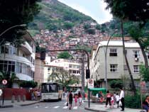 Una moderna strada di Rio de Janeiro con, sullo sfondo, le squallide favelas.