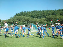 Immagine raffigurante un gruppo di bambini che entrano in campo per giocare una partita.