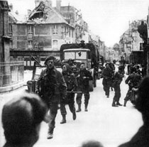 Truppe britanniche del 47esimo Comando dei marines avanzano nei villaggi della Normandia