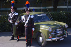 Due Allievi Carabinieri accanto all'auto di servizio d'epoca Fiat 1100