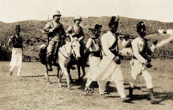 Asmara (Eritrea), 1898: un appuntato e un carabiniere 'a cavallo' nell'uniforme bronzo chiaro prescritta per il Corpo Speciale d'Africa nel settembre 1887. I militari indigeni 'a piedi' sono degli zaptié.