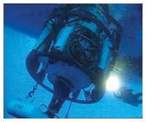 Altofondalista mentre ispeziona con un faro la campana iperbarica